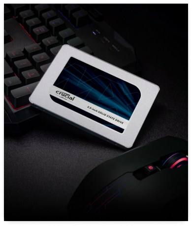 A Crucial 2.5-inch SSD leaning against a keyboard.